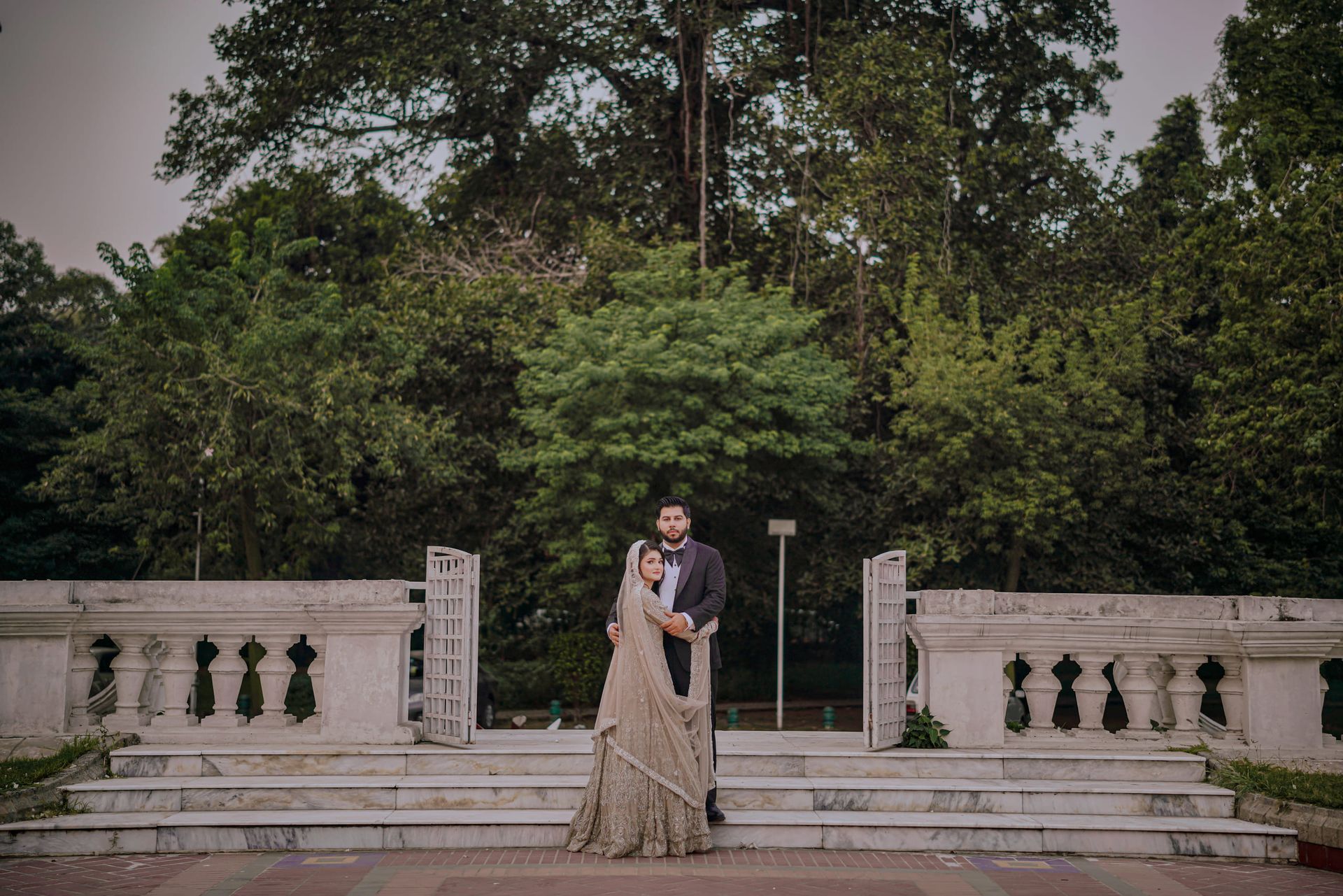 Couple on a marble garden terrace with a balustrade and open gate, Lahore couple shoot