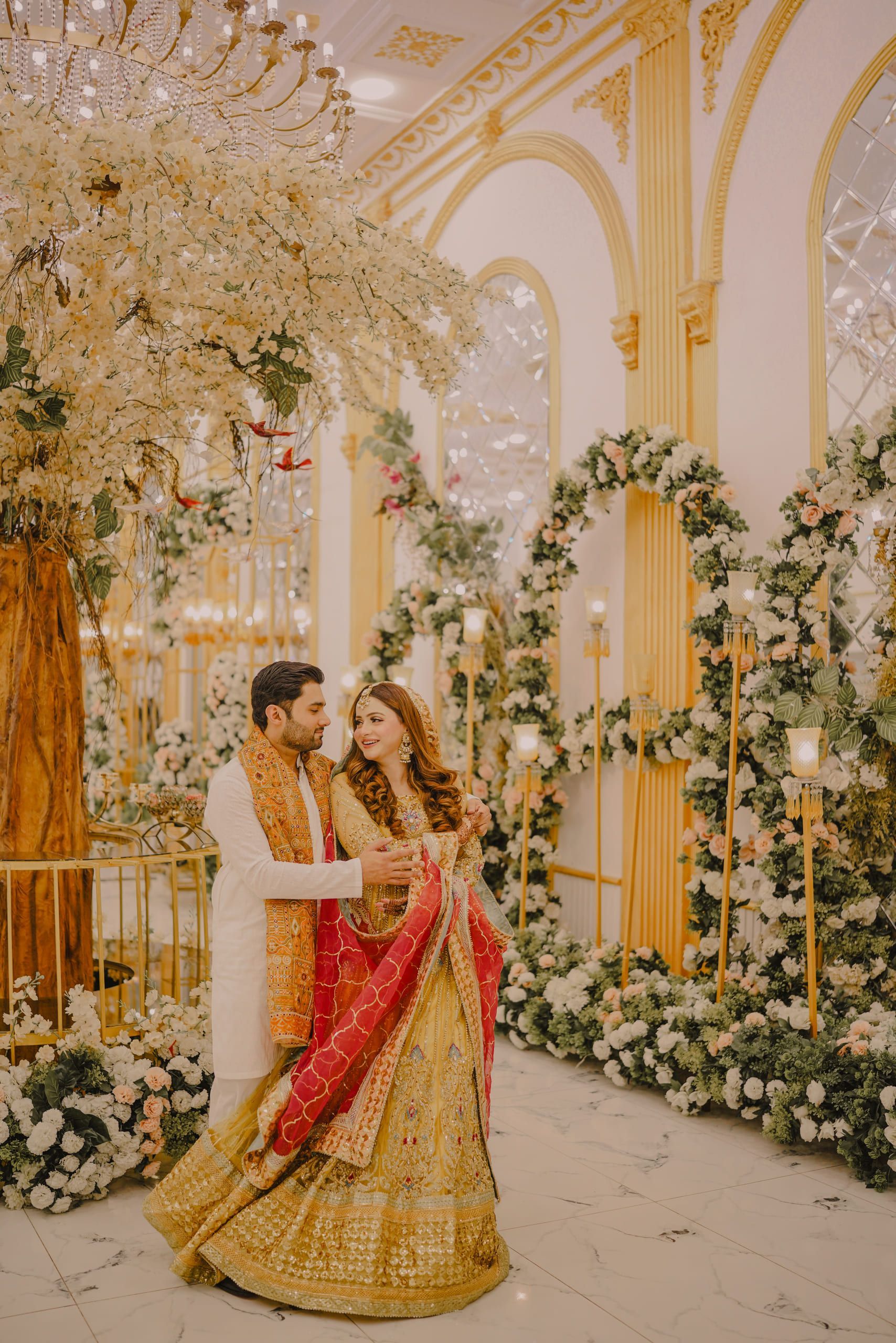 Couple at a floral mehndi setup in yellow, Lahore mehndi photography